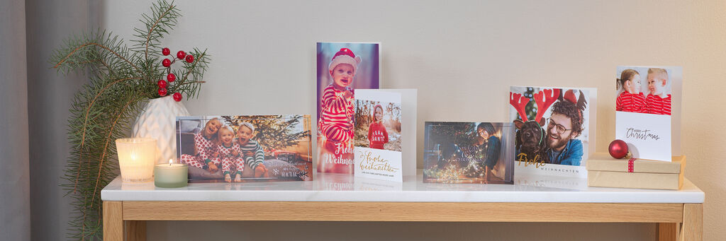 Verschiedene weihnachtliche Grusskarten stehen auf einem dekorierten Tisch.